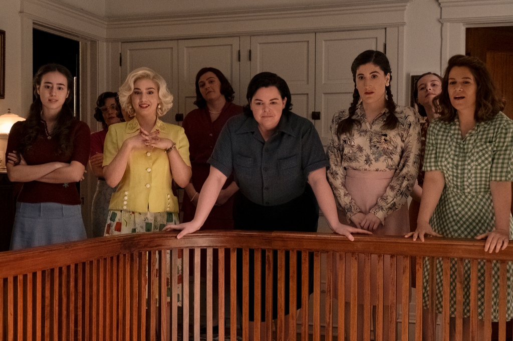 Team members Esti (Priscilla Delgado), Maybelle (Molly Ephraim), Jo (Melanie Field) Shirley (Kate Berlant), and Carson (Abbi Jacobson) right stand by a staircase balcony. 