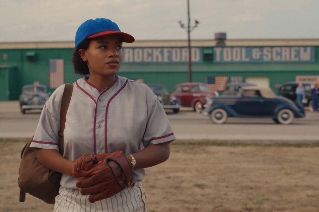 Max (Chanté Adams)  stands in a dugout holding a baseball mitt in "A League of Their Own." 