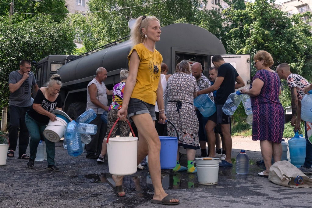 Local people replenish their supplies from a water tank truck of the Russian Armed Forces in Lysychansk.