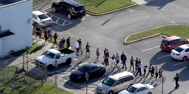 Police evacuate students at Marjory Stoneman Douglas High School in Parkland, Florida, after Nikolas Cruz opened fire February 14, 2018, killing 17 students and staff. 