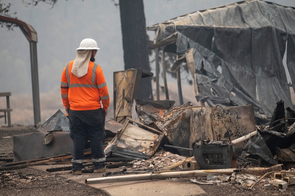 A utility worker looks over the destroyed community center in the unincorporated community of Klamath River after it was burned over by the 58,600-acre McKinney wildfire. 