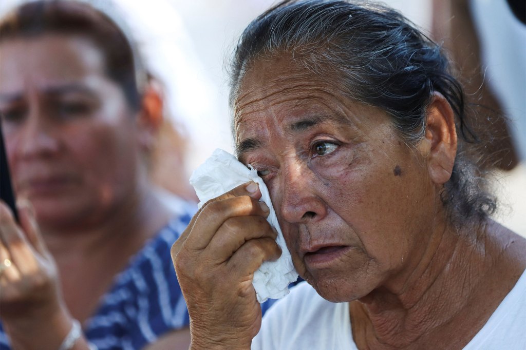 The relative of a miner wipes the tears from her eyes while waiting for information outside the premises of a coal mine which collapsed leaving miners trapped, in Sabinas, i
