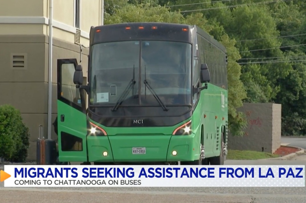 Migrants hop on a charter bus.