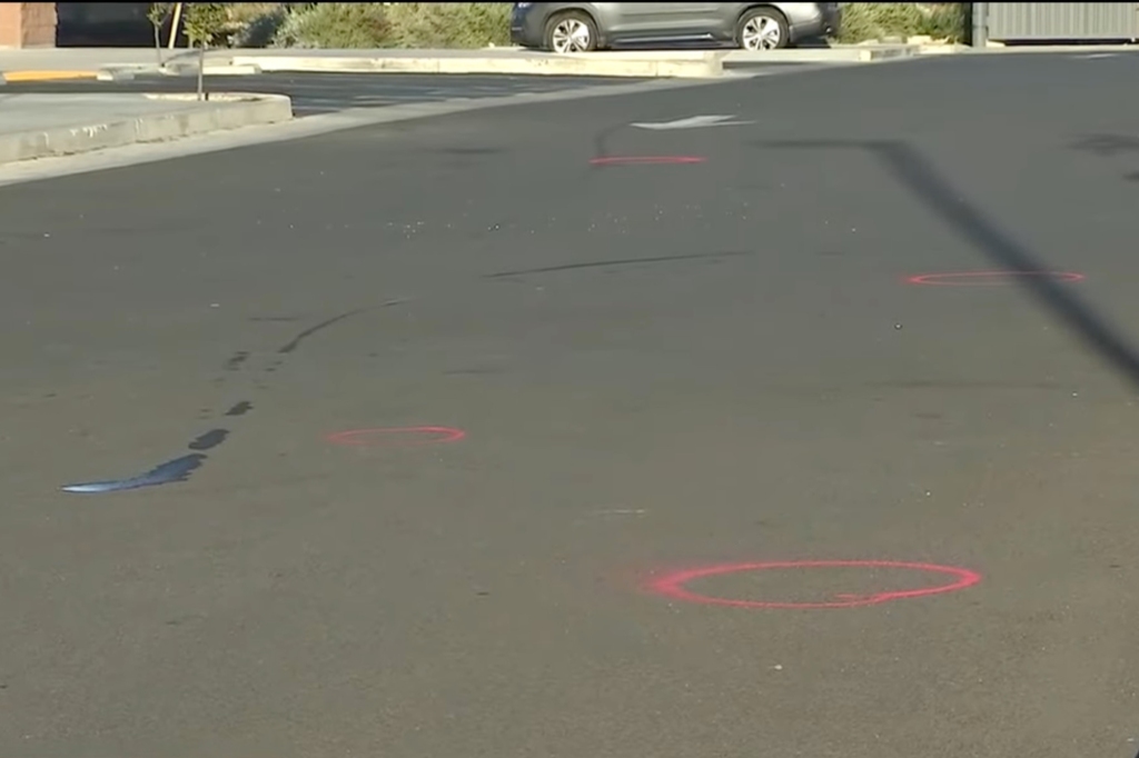 Evidence markers are seen at the gym parking lot, where one man was pronounced dead early Thursday. 