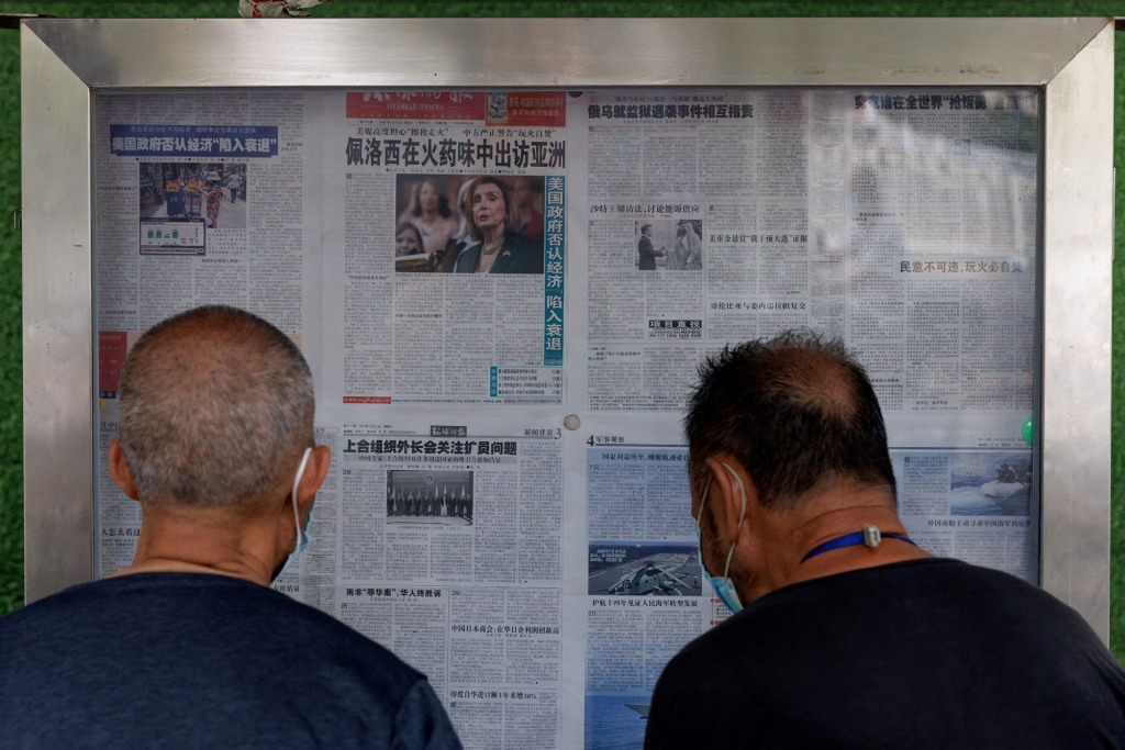 Two men read the Global Times newspaper cover highlight House Speaker Nancy Pelosi’s Asia tour in Beijing, China on August 1, 2022.