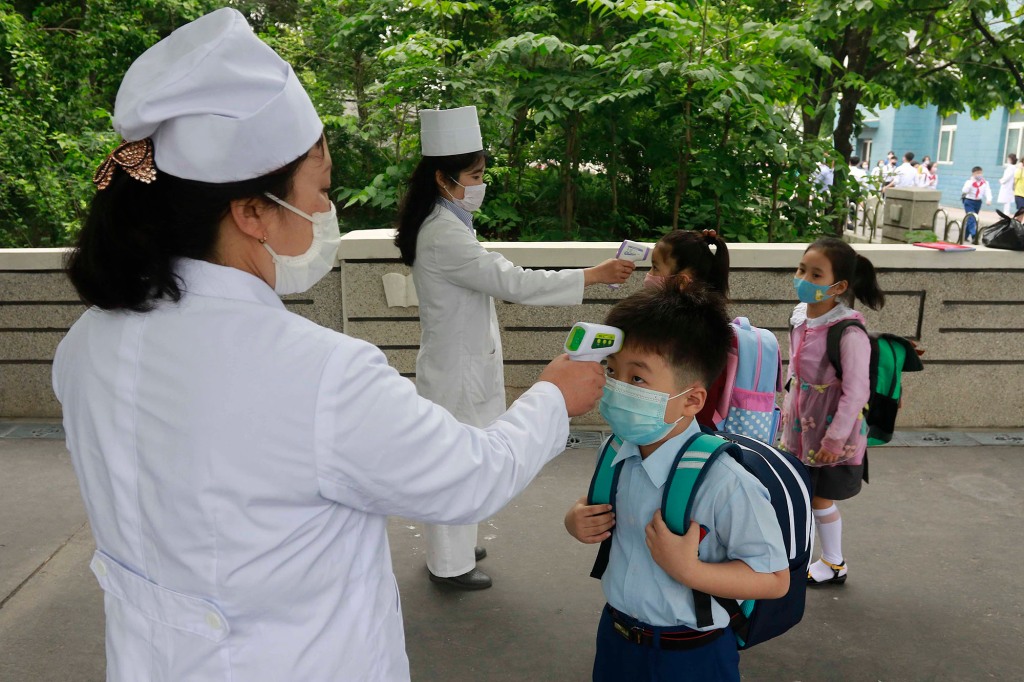 Children having their temperature taken before school.