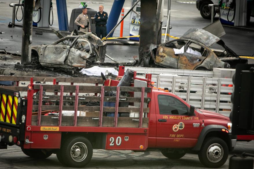 A truck picking up broken car pieces after the crash.