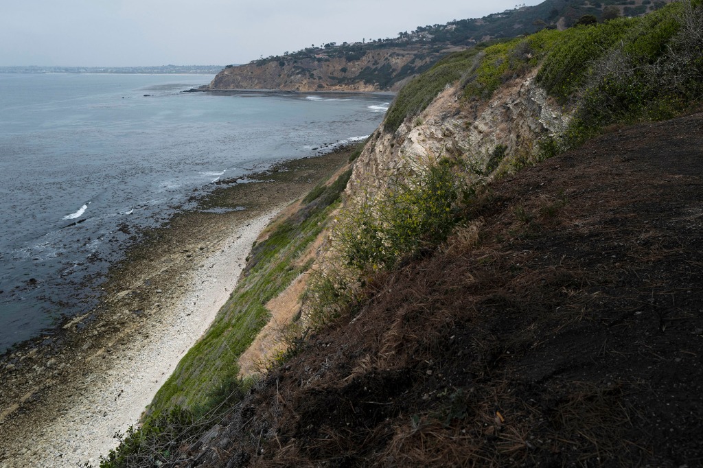 Small waves crash into the beach surrounded by cliffs in Palos Verdes Estates, Calif., Monday, May 23, 2022.Four people fell off a Southern California ocean cliff in the early morning darkness on Monday and a man was killed and two women were critically injured, authorities said. 