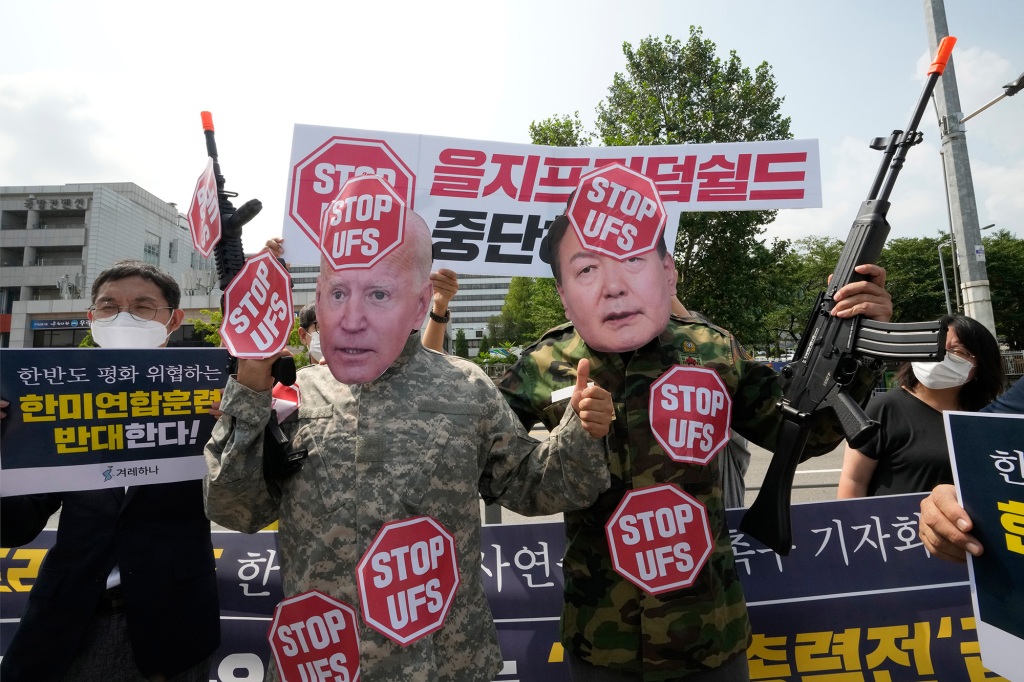 Protesters, two of which are wearing masks of U.S. President Joe Biden, left, South Korean President Yoon Suk Yeol, stage a rally to oppose planned joint military exercises, called the Ulchi Freedom Shield, between South Korea and the United States on the occasion of U.S. House of Representatives Speaker Nancy Pelosi's visit in South Korea, in front of the presidential office in Seoul, South Korea, Thursday, Aug. 4, 2022. The banner reads, "Stop the Ulchi Freedom Shield." (AP Photo/Ahn Young-joon)
