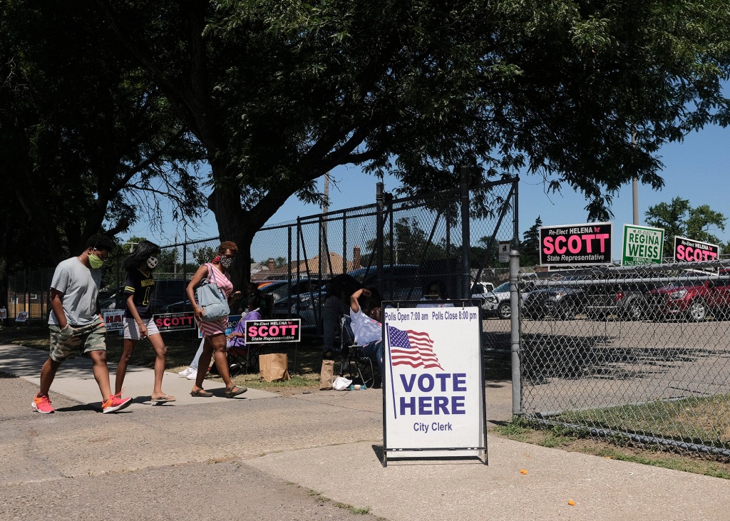 Michigan residents their ballots in the Michigan primary election on August 2, 2022.