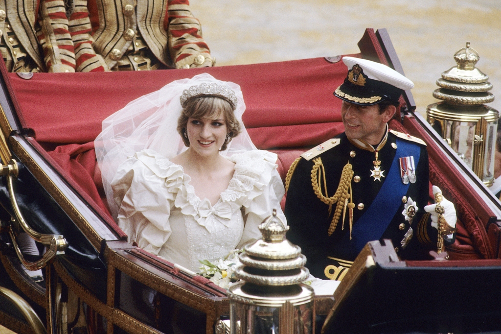 LONDON, ENGLAND - JULY 29: Prince Charles, Prince of Wales and Diana, Princess of Wales, wearing a wedding dress designed by David and Elizabeth Emanuel and the Spencer family Tiara, ride in an open carriage, from St. Paul's Cathedral to Buckingham Palace, following their wedding on July 29, 1981 in London, England.   (Photo by Anwar Hussein/WireImage)