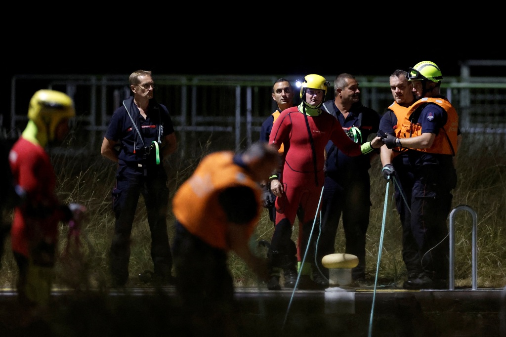 Firefighters and members of a search and rescue team conduct a mission to move a Beluga whale which strayed into the France's Seine river to a saltwater basin, near the Notre-Dame-de-la-Garenne lock in Saint-Pierre-la-Garenne, France, August 9, 2022. REUTERS/Benoit Tessier