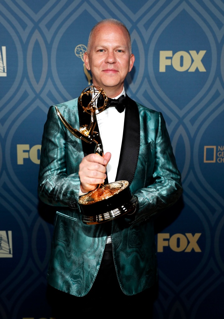 Ryan Murphy holding an Emmy Award.