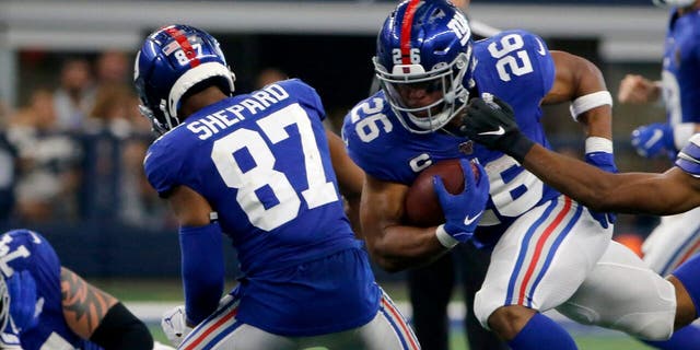 New York Giants' Sterling Shepard (87) helps clear running room for running back Saquon Barkley (26) as Dallas Cowboys cornerback Byron Jones (31) defends in the second half of a NFL football game in Arlington, Texas, Sunday, Sept. 8, 2019.