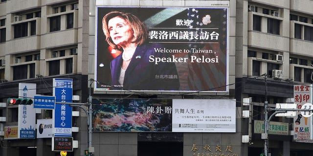 People walk past a billboard welcoming U.S. House Speaker Nancy Pelosi, in Taipei, Taiwan, Aug 3, 2022. Days after Ayman al-Zawahiri was killed in Kabul, China staged large-scale military exercises and threatened to cut off contacts with the U.S. over House Speaker Nancy Pelosi's visit to Taiwan.