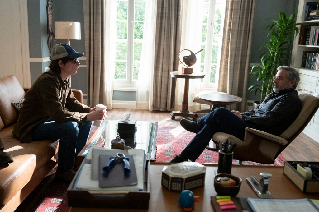 Scene from "The Patient" showing Sam, who's using an alias, sitting across from Dr. Alan Strauss during a therapy in Strauss' home office. Sam is wearing a baseball cap and dark sunglasses; Alan is leaning back in an easy chair and has his leges crossed. He's listening to Sam talk.