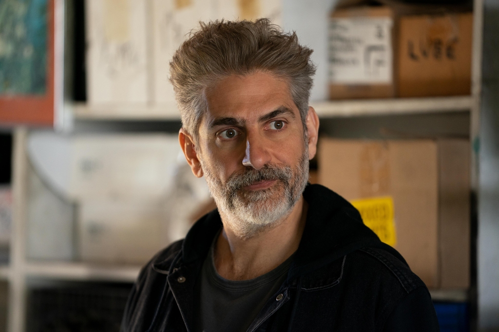 Michael Imperioli as Minister Payne in "This Fool." He's wearing a black jacket/sweatshirt and has a grey-ish beard. He's looking off-camera and isn't smiling.