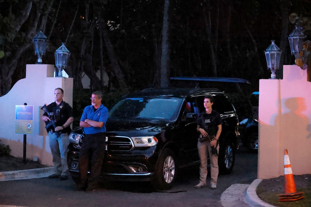 Armed Secret Service agents stand outside an entrance to former President Donald Trump's Mar-a-Lago estate.