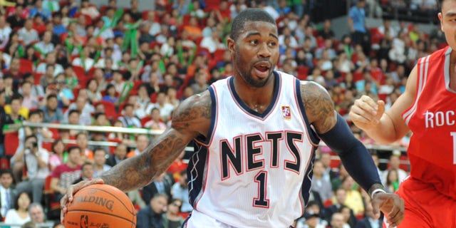 Terrence Williams #1 of the New Jersey Nets drives against Yao Ming #11 of the Houston Rockets during the game on October 16, 2010, at the Guangzhou International Sports Arena in Guangzhou, China.