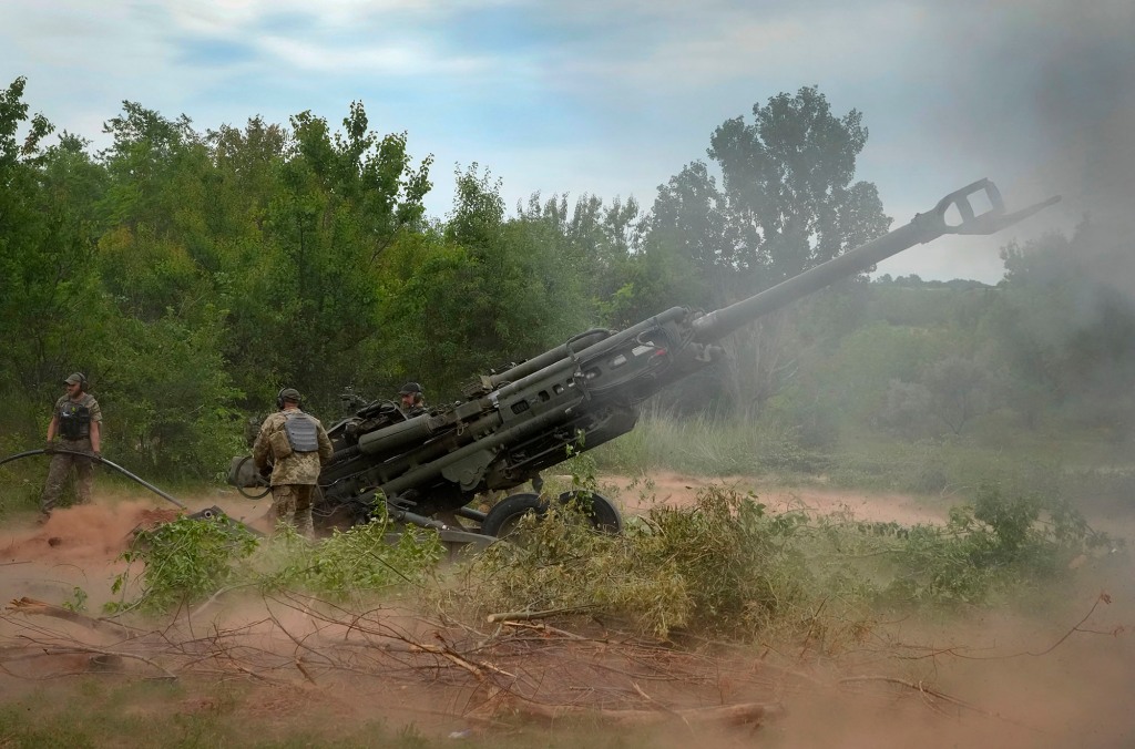 Ukraine soldiers fire using a U.S.-supplied M777 howitzer on the battlefield. 
