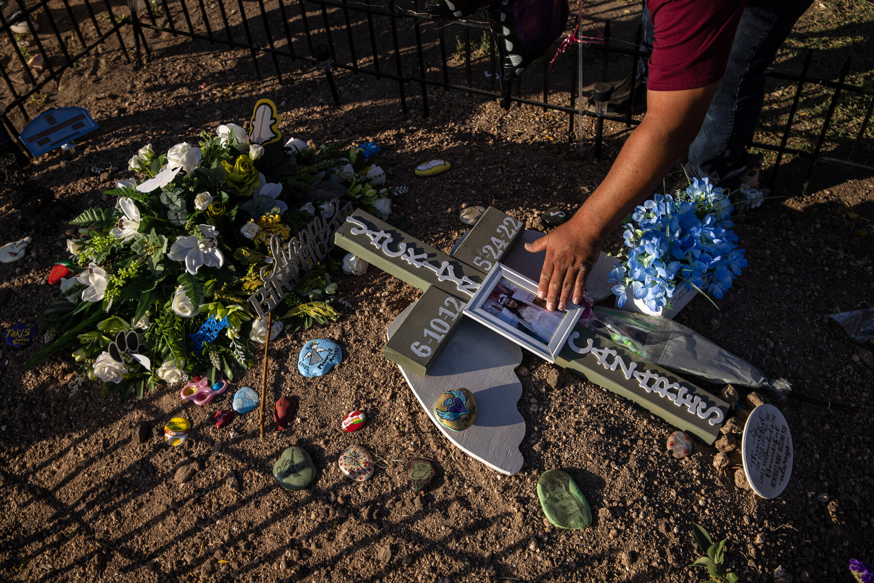 Javier Cazares touches a framed photo of his daughter Jackie, 9, while visiting her grave at Hillcrest Memorial Cemetery.