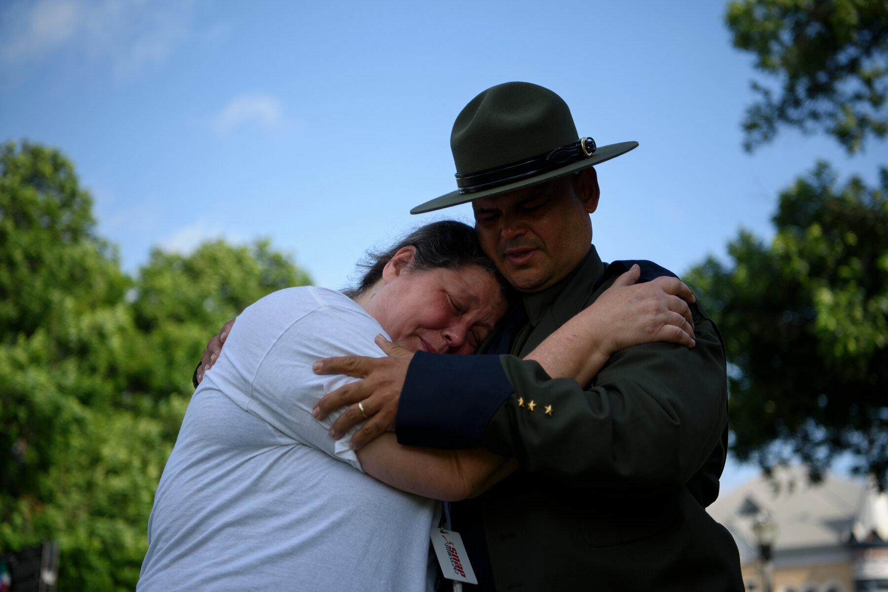 A Border Patrol agent hugged a community member at a memorial ceremony.