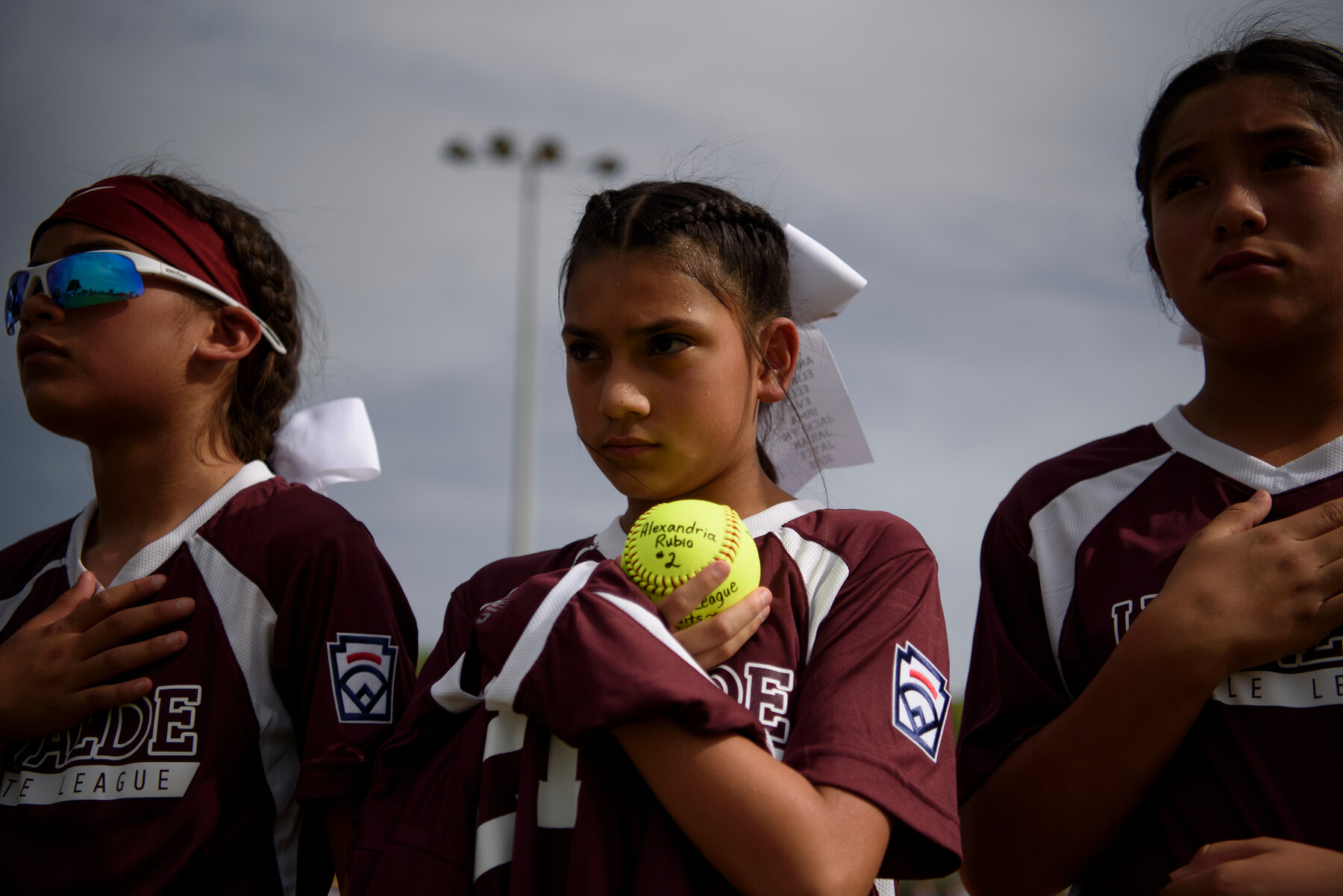 During the district all-star tournament, Marlehn Arellano, 10, held a softball during a ceremony honoring the victims.