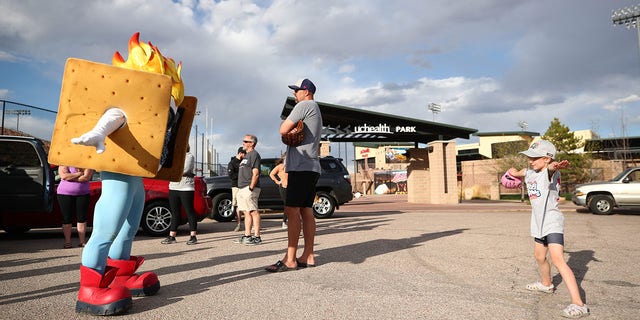 Rocky Mountain Vibes mascot Toasty in parking lot with fans.