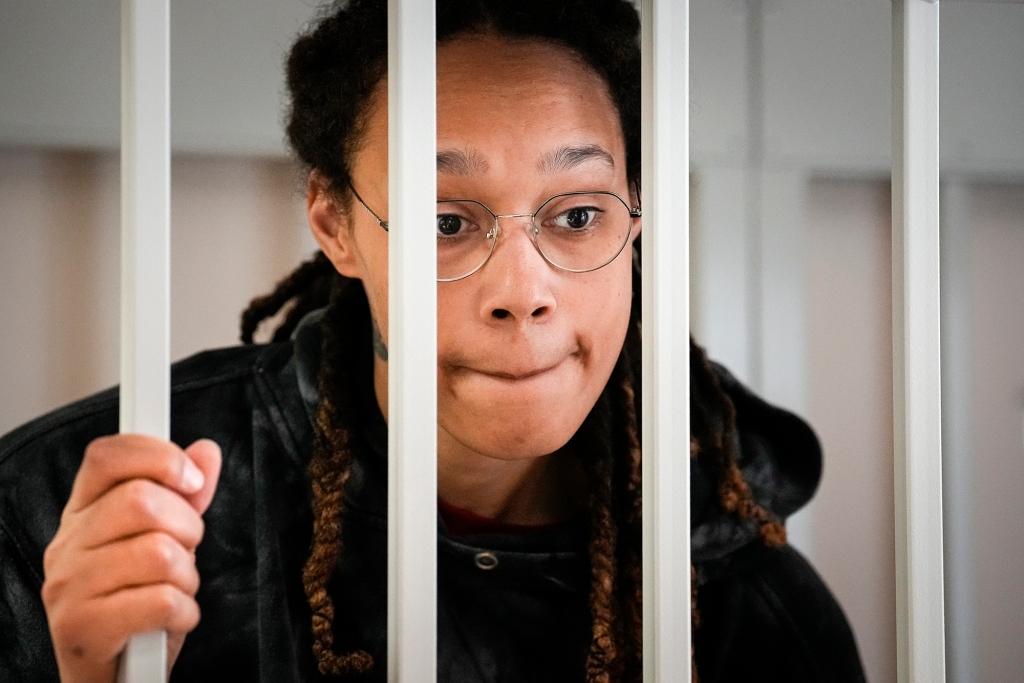 WNBA star and two-time Olympic gold medalist Brittney Griner speaks to her lawyers standing in a cage at a court room prior to a hearing, in Khimki just outside Moscow, Russia, Tuesday, July 26, 2022. 