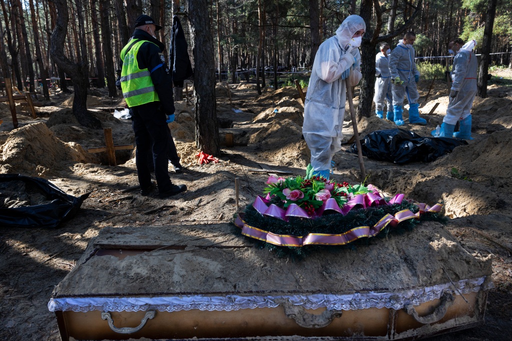 Rescue workers and forensic police exhume bodies from unidentified makeshift graves at the Pishanske cemetery on Sept. 21, 2022 in Izium, Ukraine. 