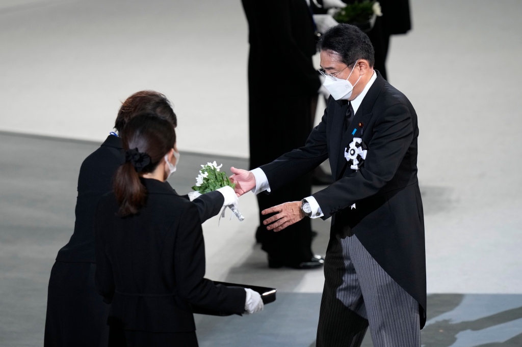 Japan’s Prime Minister Fumio Kishida (right) approaches the alter to lay flowers during the state funeral for Shinzo Abe on Sept. 27, 2022 in Tokyo.