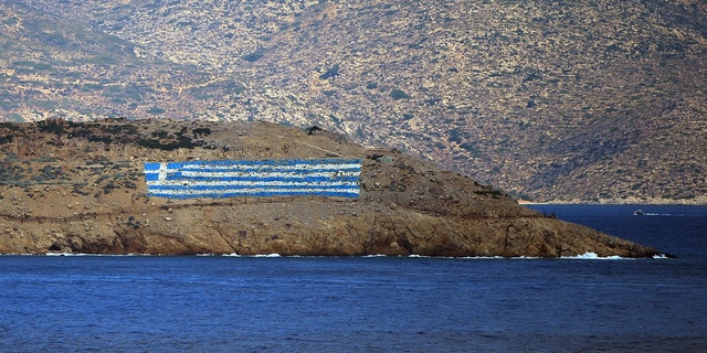 The Greek flag painted on a hill on Pserimos Island. Turkey claims Greece is violating international treaties by what it says is its militarization of its Islands in the eastern Aegean Sea.