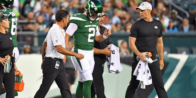 New York Jets quarterback Zach Wilson, #2, is helped off the field against the Philadelphia Eagles during the first quarter at Lincoln Financial Field.