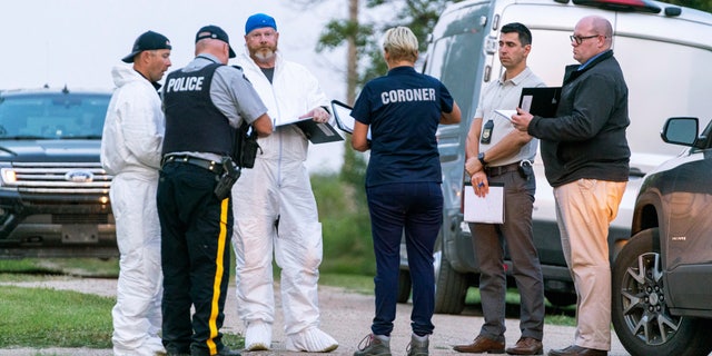 Investigators gather in front of the scene of a stabbing in Weldon, Saskatchewan, on Sunday, Sept. 4. 