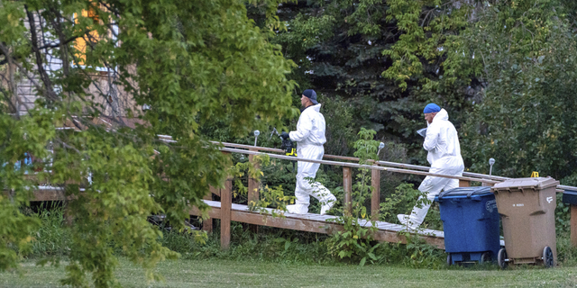 Investigators enter a house at the scene of a stabbing in Weldon, Saskatchewan, on Sunday, Sept. 4.