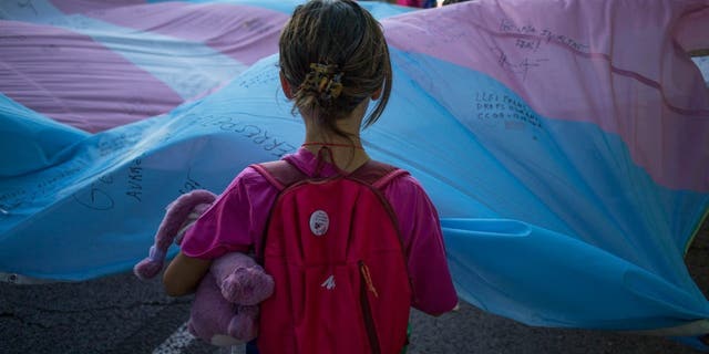 A girl holds the transgender pride flag during the pride march in Madrid July 9, 2022.