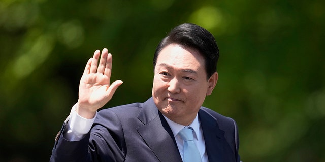 South Korea's President Yoon Suk Yeol waves from a car after the Presidential Inauguration outside the National Assembly in Seoul, South Korea, May 10, 2022.