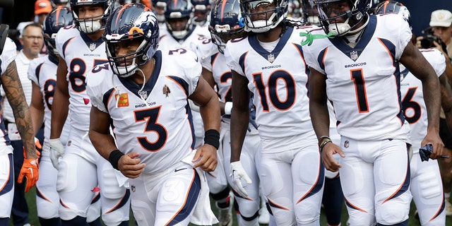 Denver Broncos quarterback Russell Wilson, #3, runs out of the tunnel with teammates at the start of an NFL football game against the Seattle Seahawks, Monday, Sept. 12, 2022, in Seattle. 