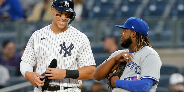 Aaron Judge, #99 of the New York Yankees, in action against Vladimir Guerrero Jr., #27 of the Toronto Blue Jays, at Yankee Stadium on April 13, 2022, in New York City. The Blue Jays defeated the Yankees 6-4.