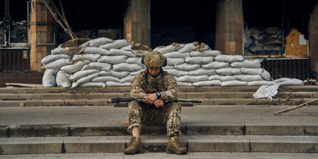 A Ukrainian soldier takes a rest on the steps of the City Hall in Izium, Kharkiv region, Ukraine, Tuesday, Sept. 13, 2022. Ukrainian troops piled pressure on retreating Russian forces Tuesday, pressing deeper into occupied territory and sending more Kremlin troops fleeing ahead of the counteroffensive that has inflicted a stunning blow on Moscow's military prestige. 