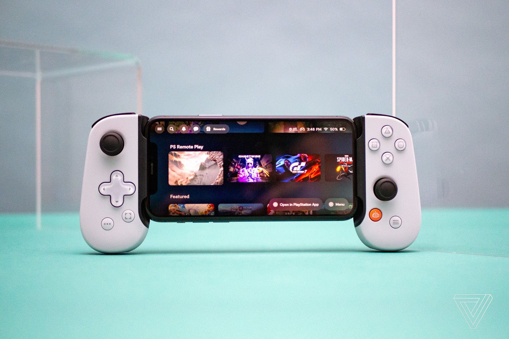 An iPhone 12 Pro sitting inside of Backbone’s One controller that has a Sony PlayStation-like design.