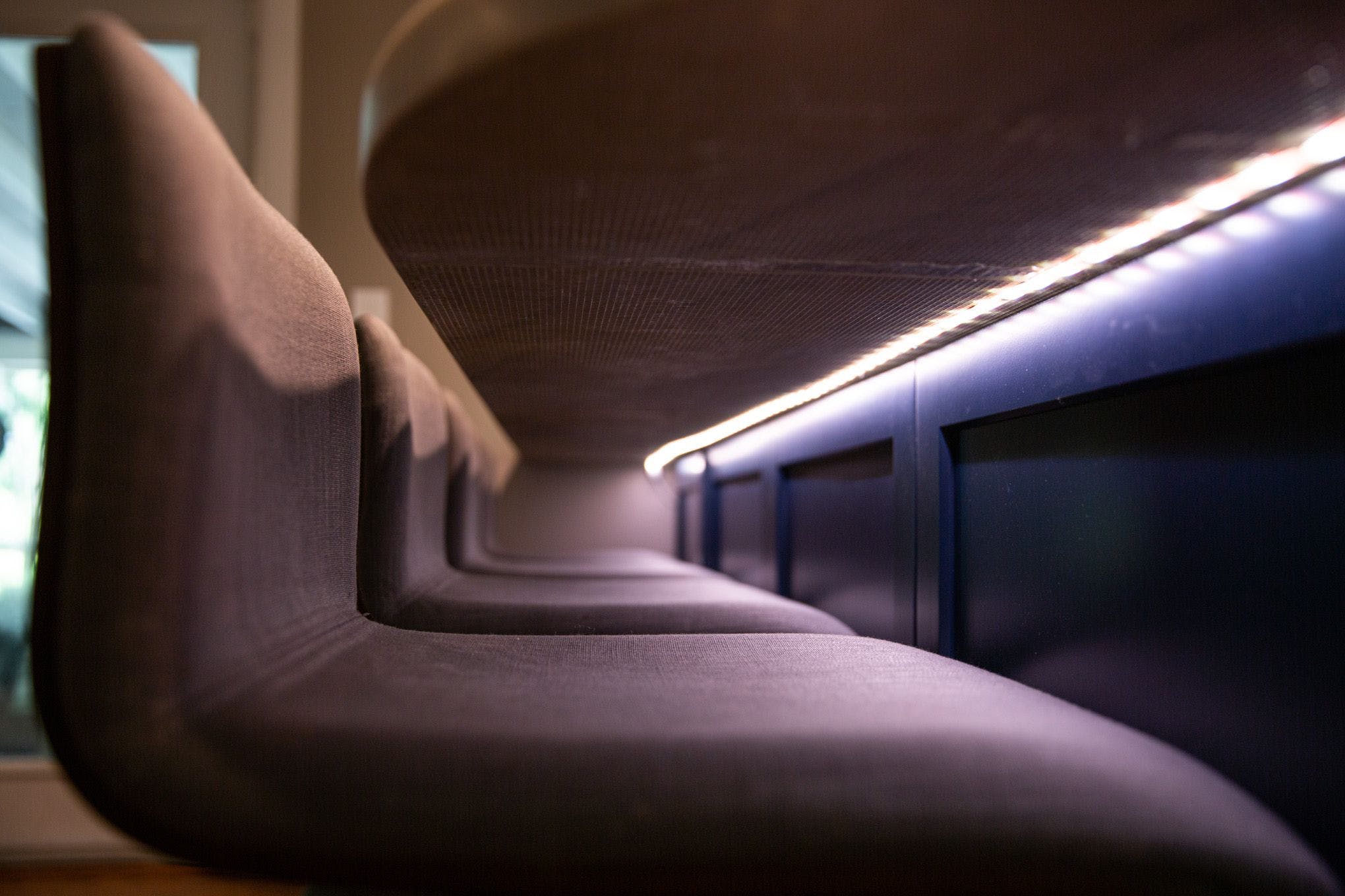 A light strip under a counter next to chairs