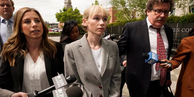 Sherri Papini walks to the federal courthouse accompanied by her attorney, William Portanova, right, in Sacramento, California, Wednesday, April 13, 2022. 