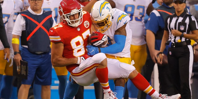 Travis Kelce (87) of the Kansas City Chiefs is tackled by Derwin James Jr. (3) of the Los Angeles Chargers during the first quarter at Arrowhead Stadium in Kansas City on Sept. 15, 2022.