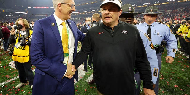 Head coach Kirby Smart, right, of the Georgia Bulldogs, shakes hands with SEC Commissioner Greg Sankey after the Bulldogs defeated the Alabama Crimson Tide 33-18 in the 2022 CFP National Championship Game at Lucas Oil Stadium Jan. 10, 2022, in Indianapolis. 