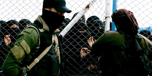 Women speak to guards at the gate that closes off the section for foreign families who lived in the Islamic State's so-called caliphate, at Al-Hol camp in Hasakeh province, Syria, March 31, 2019.