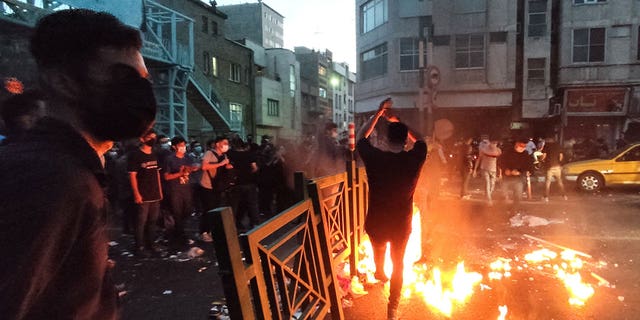 People light a fire during a protest over the death of Mahsa Amini, a woman who died after being arrested by the Islamic republic's "morality police", in Tehran, Iran Sept. 21, 2022. 