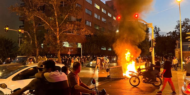 A police motorcycle burns during a protest over the death of Mahsa Amini, a woman who died after being arrested by the Islamic republic's "morality police" in Tehran, Iran, Sept. 19, 2022. 