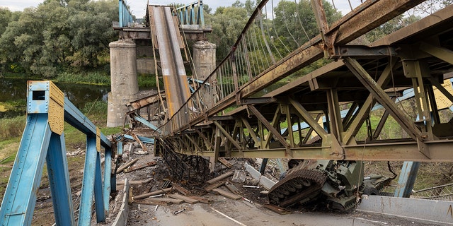 IZYUM, UKRAINE - SEPTEMBER 20: A Russian tank and a destroyed bridge are seen September 20, 2022 in Izyum, Ukraine. Izyum was occupied by Russians since  April 1st causing major destruction and death to the small city.  In recent weeks, Ukrainian forces have reclaimed villages east and south of Kharkiv, as Russian forces have withdrawn from areas they've occupied since early in the war. 