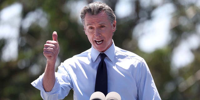 FILE: California Gov. Gavin Newsom speaks during a visit to Chabot Space &amp; Science Center with U.S. Vice President Kamala Harris on August 12, 2022, in Oakland, California. Newsom has accused Florida Gov. Ron DeSantis of breaking laws by flying illegal migrants to Martha's Vineyard, but Newsom appears to have broken California's law banning travel to some states. 